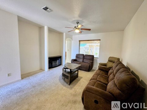 A living room with a row of brown chairs and a fireplace.