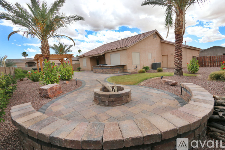 A backyard with a fire pit and palm trees.