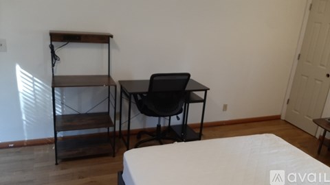 A room with a bed, a chair, and a desk.