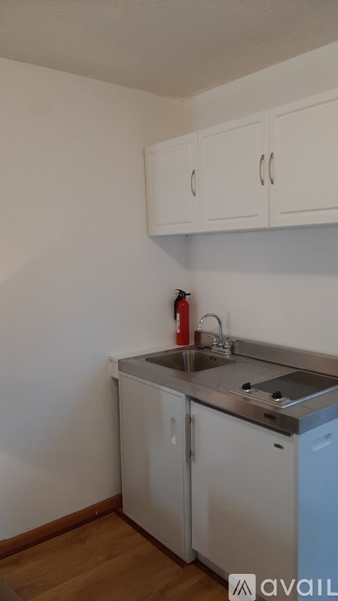 A kitchen with white cabinets and a stainless steel sink.