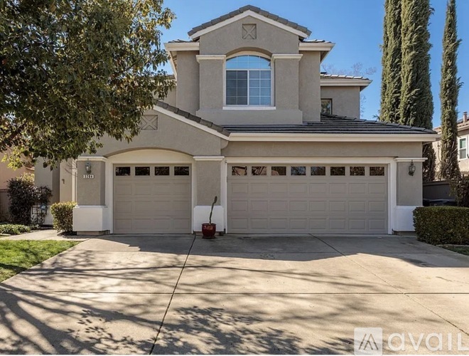 A house with a garage and a driveway is available for sale.