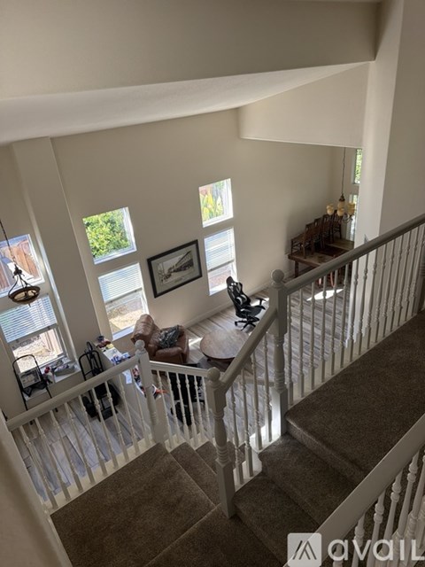 A living room with a couch and a chair with a window behind it.