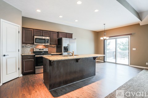 A kitchen with a black island in the middle of the room.