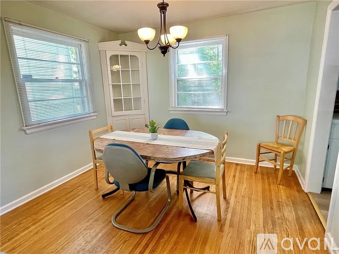 A dining room with a wooden table and chairs.