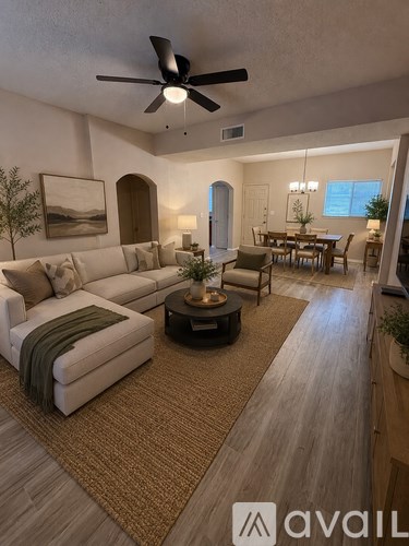 A living room with a white couch and a ceiling fan.