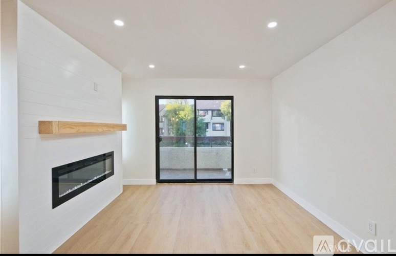 A spacious room with a fireplace and sliding glass doors.