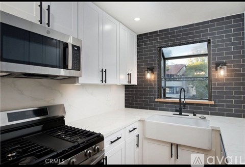 A kitchen with white cabinets and a black stove top oven.