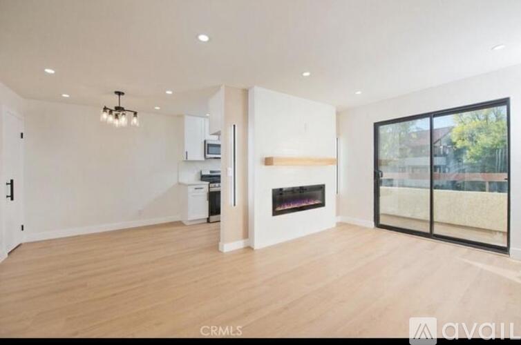 A spacious living room with wood flooring and a fireplace.
