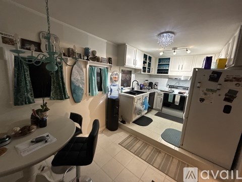 A kitchen with a table and chairs in the foreground and a refrigerator in the background.