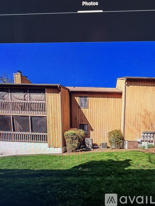 A building with a brown facade and a green lawn in front.