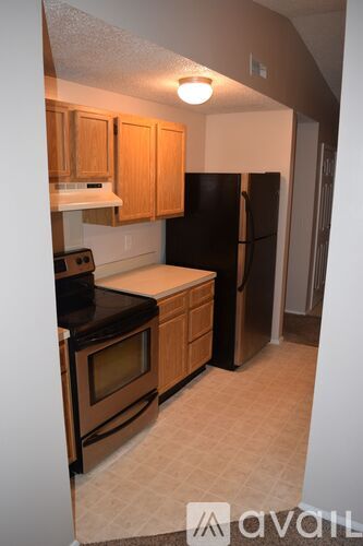 A kitchen with wooden cabinets and black appliances.