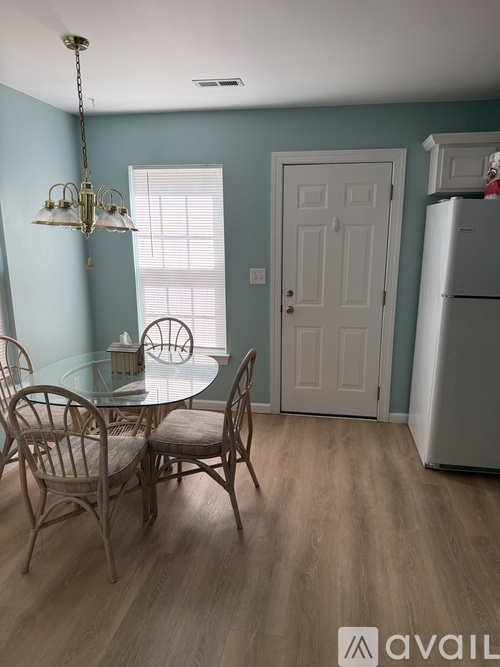 A dining room with a glass table and chairs.