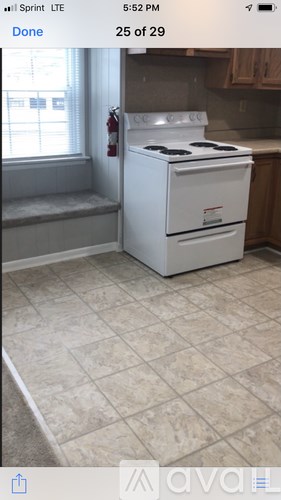 A white stove in a kitchen with tile flooring.