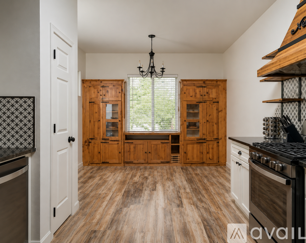 A kitchen with wooden cabinets and a black stove top oven.