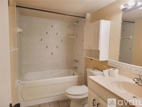 A bathroom with a white tub, toilet, and sink.