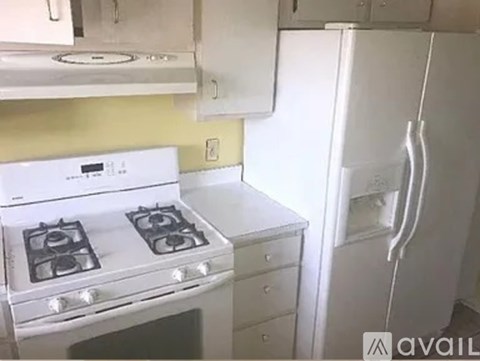 A white stove and refrigerator in a kitchen.