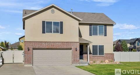 A house with a garage and a fence in front of it.