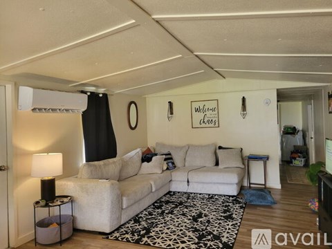 A living room with a white couch and a black and white rug.