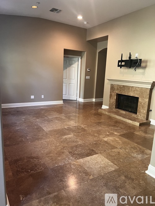 A living room with a fireplace and a flat screen TV mounted above it.