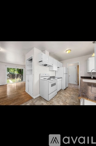 A modern kitchen with white cabinets and appliances.