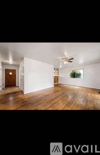 A room with wooden floors and a ceiling fan.