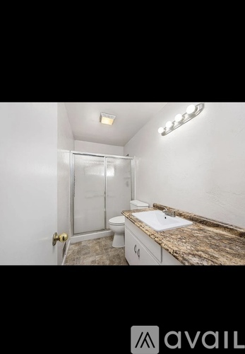 A bathroom with a toilet, sink, and shower.