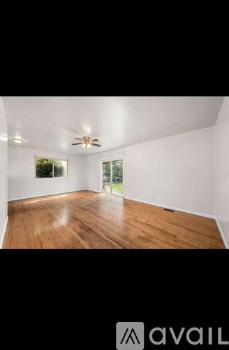 A room with wooden floors and a ceiling fan.