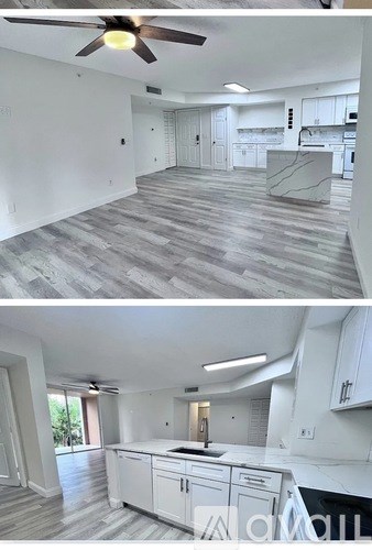 A modern kitchen with white cabinets and a ceiling fan.