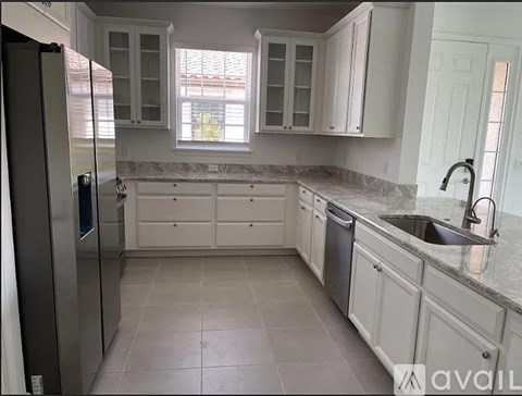 A kitchen with white cabinets and a granite countertop.