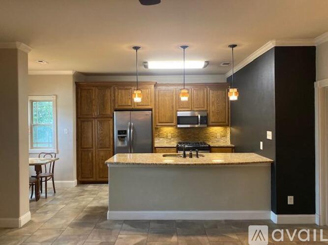 A kitchen with wooden cabinets and a marble countertop.