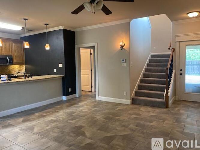 A spacious living room with a staircase leading to the upper floor.