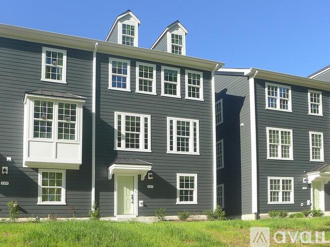 A row of houses with grey exteriors and white trim.