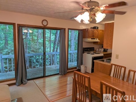A kitchen with a table and chairs and a fan.