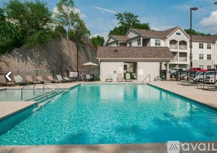 A swimming pool in front of a building with a sign that says "available".