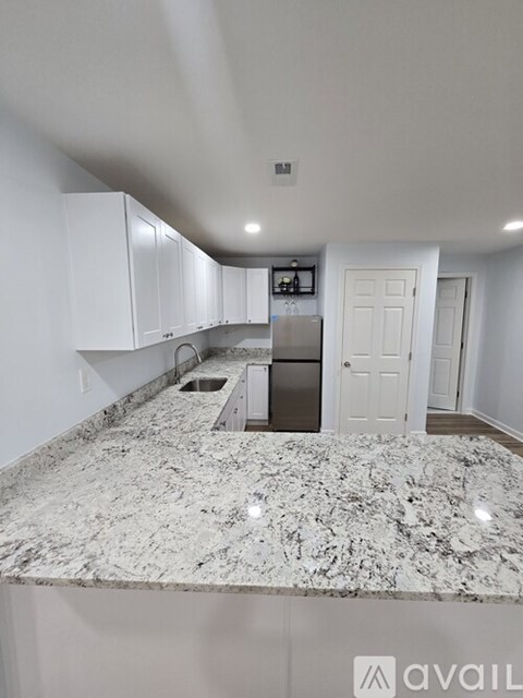 A kitchen with granite countertops and white cabinets.
