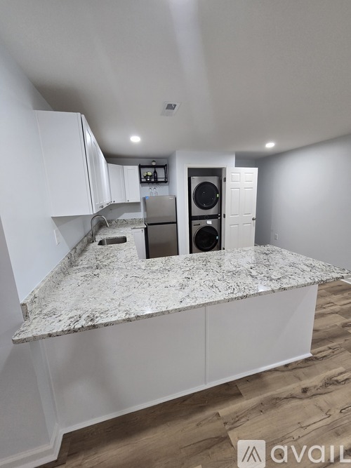 A kitchen with granite countertops and white cabinets.