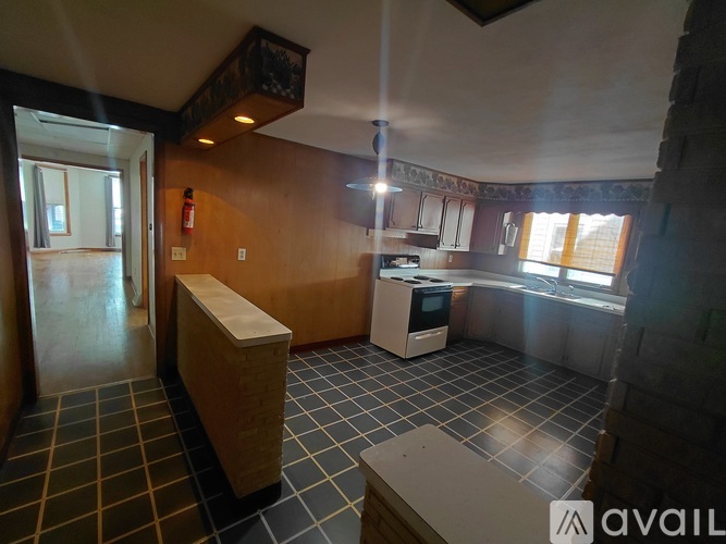 A kitchen with a tile floor and a window.