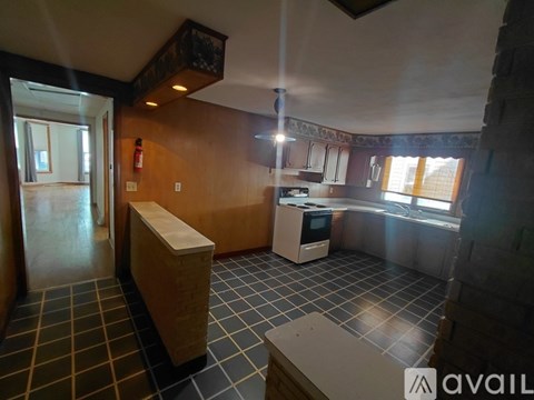 A kitchen with a tile floor and a window.