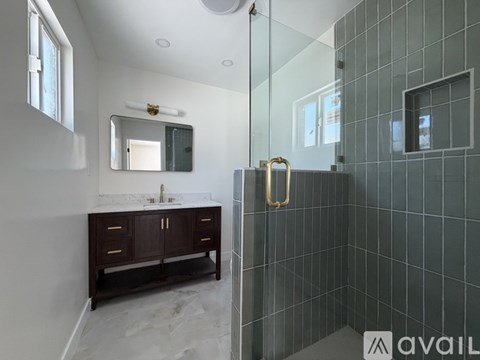 A bathroom with a sink, mirror, and tiled walls.