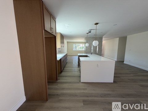 A spacious kitchen with wooden cabinets and a white island.