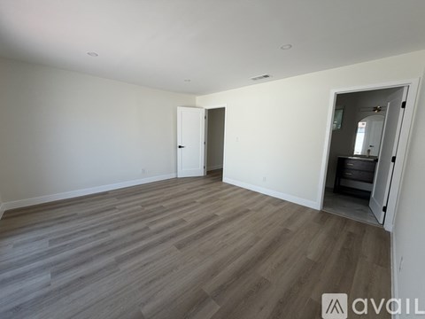 A room with wooden flooring and a white door.