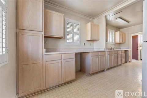 A kitchen with wooden cabinets and a tiled floor.