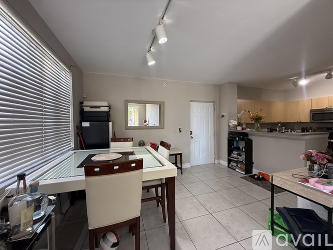 A kitchen with a dining table and chairs.
