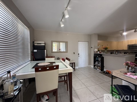 A kitchen with a dining table and chairs.