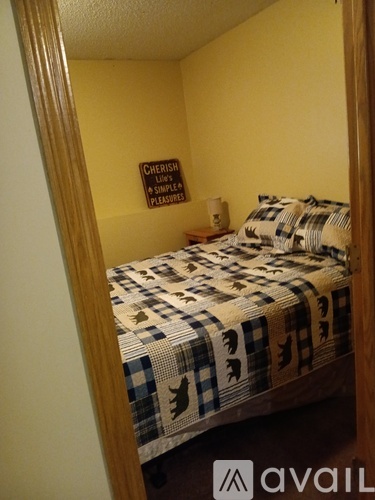 A bedroom with a bed and a sign on the wall.