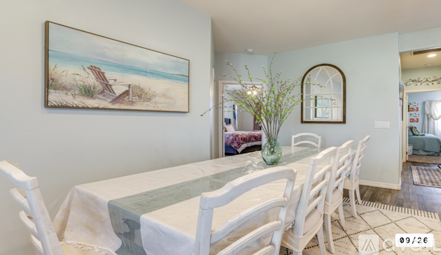 A dining room with a white table and chairs.