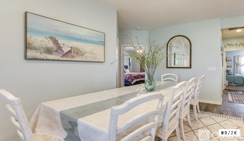 A dining room with a white table and chairs.