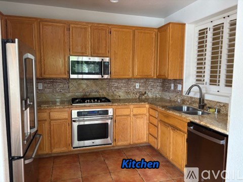 A kitchen with wooden cabinets and a tile floor.