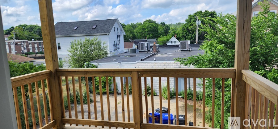 A balcony with a view of a parking lot and buildings.