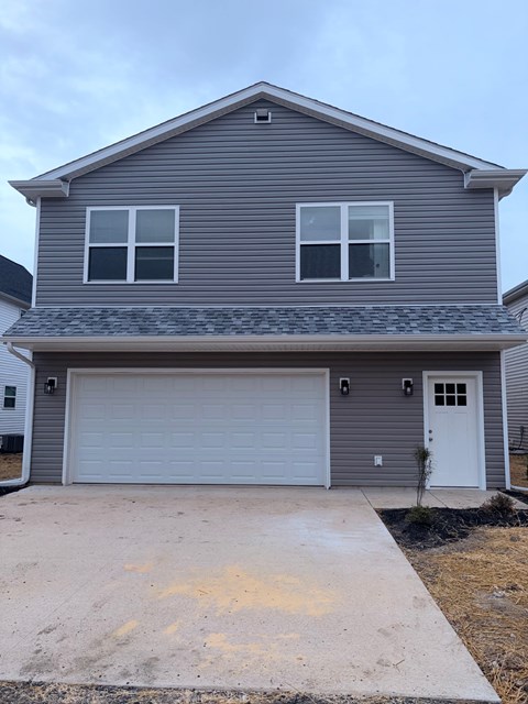 A grey house with a white garage door.